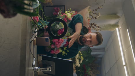 el florista recoge el ramo y mira a la cámara