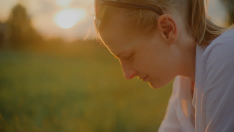 close-up of woman looking into baby stroller at sunset
