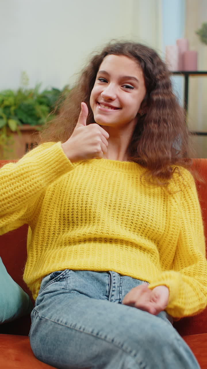 Happy child kid girl looking approvingly at camera showing thumbs up like positive sign good news