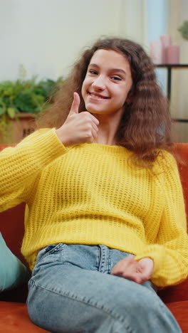 happy child kid girl looking approvingly at camera showing thumbs up like positive sign good news