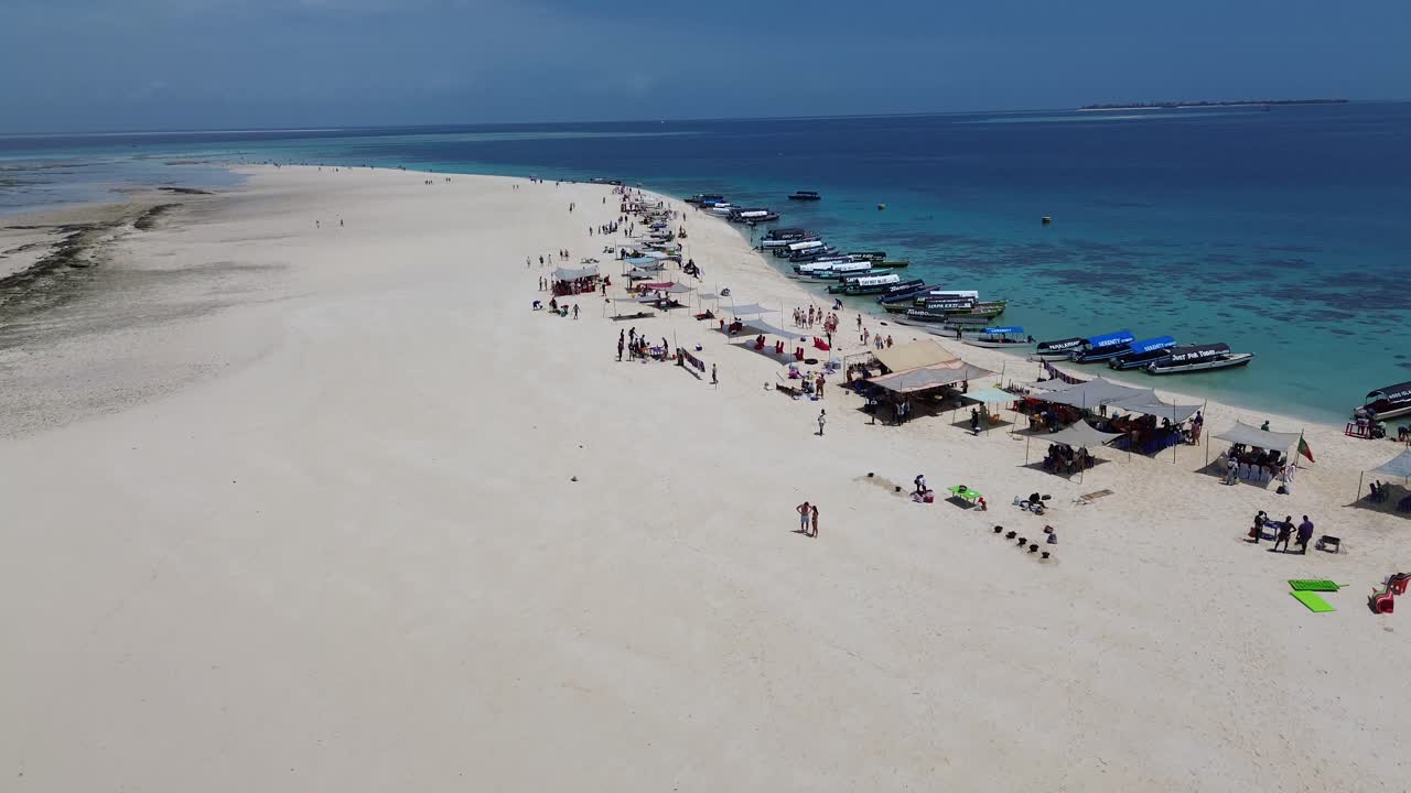 View of Nakupenda Island with tourist bathing and guides organising lunch