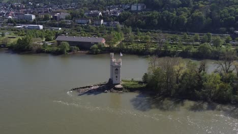 Tracking-aerial-Orbit-of-River-toll-Mouse-Tower-sitting-on-a-small-isle-on-Rhine-River-near-Bingen,-Germany