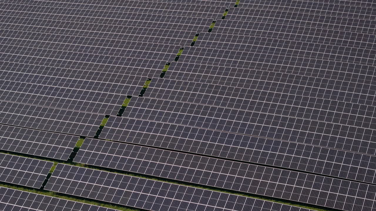 독일의 초록색 언덕에 있는 여러 개의 태양광 패널을 가진 거대한 태양광 발전소에서 아래로 기울어서 날아갑니다. 신재생 에너지, 항공 영상