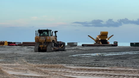 bulldozer leveling sand during beach replenishment construction project