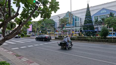 vehicles passing by a decorated mall entrance