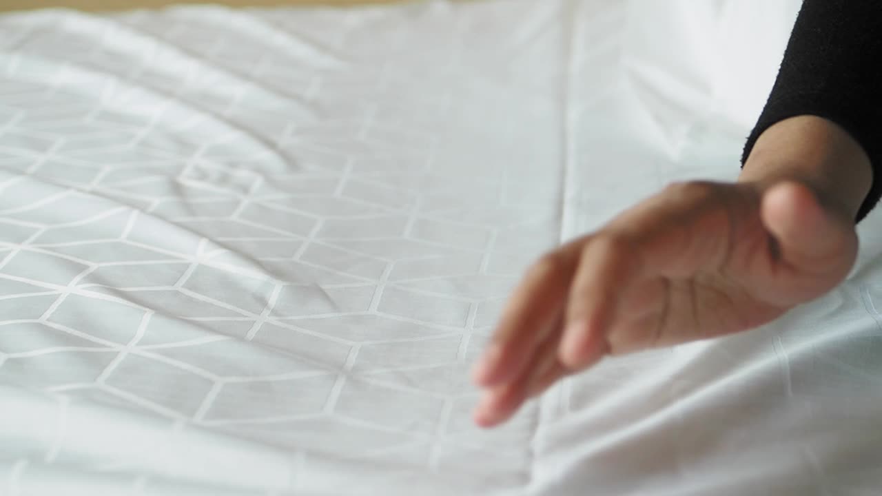 침대 시트 위에 손으로