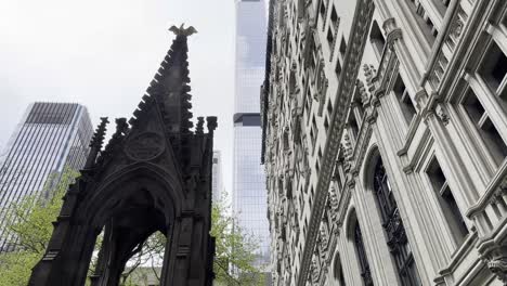 Eine-Nahaufnahme-Der-Komplizierten-Gotischen-Architektur-Der-Trinity-Church-Im-Kontrast-Zu-Den-Modernen-Wolkenkratzern-In-Lower-Manhattan,-Die-Die-Mischung-Aus-Historischem-Und-Zeitgenössischem-Design-Der-Stadt-Hervorhebt