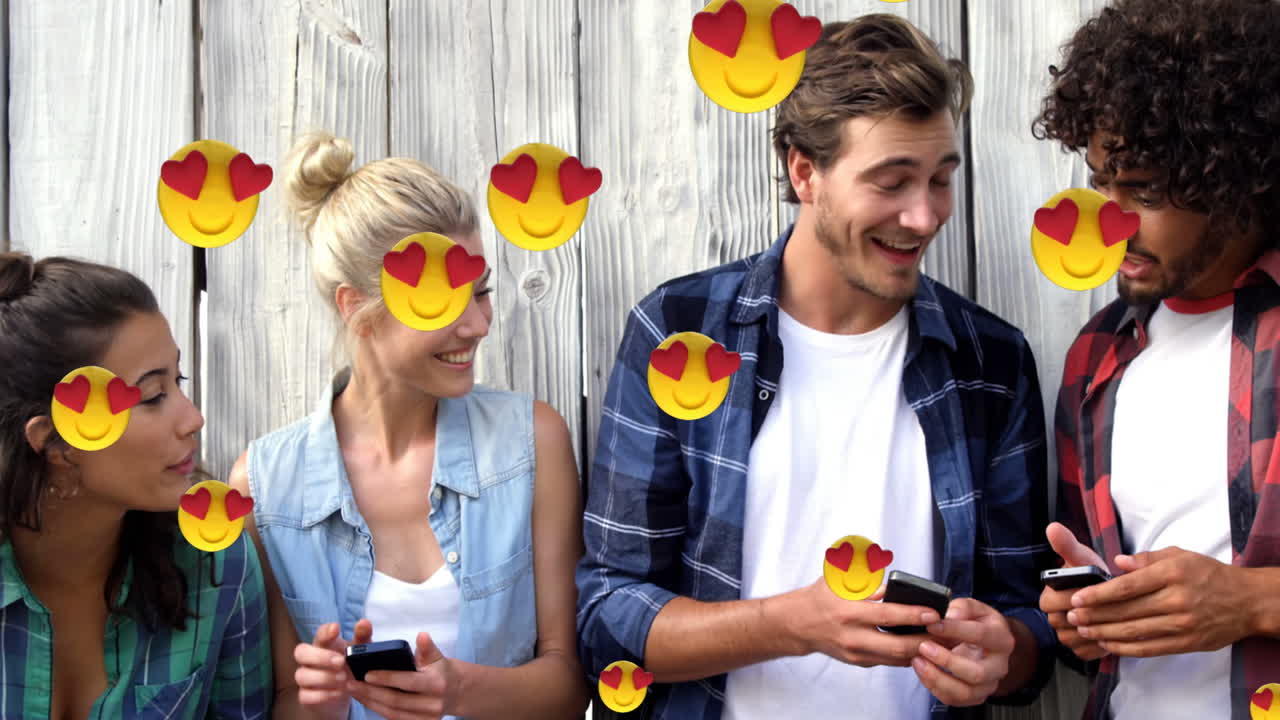ojos de corazón cara emojis flotando contra un grupo de amigos que usan teléfonos inteligentes
