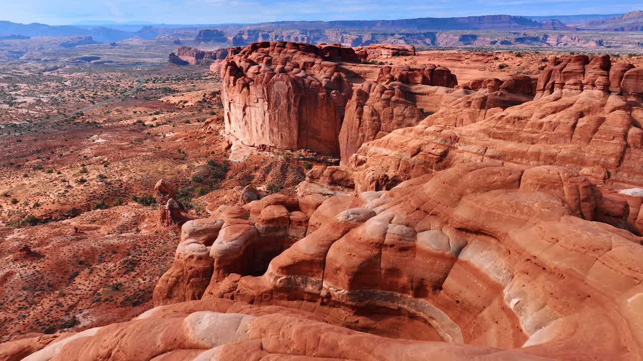 Afrundede, røde klipper uden vegetation. Ørken med spredte buske omkring. Arches Nationalpark, Utah, USA. Luftfoto