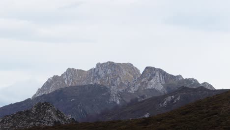 Zeitraffer-Von-Wolken,-Die-Sich-In-Der-Ferne-über-Einen-Felsigen-Berg-Bewegen