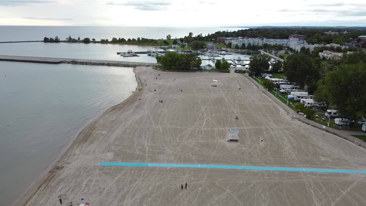 пешеходная дорожка для инвалидных колясок на песчаном пляже вблизи города, пристани для яхт и кемпинг-парка