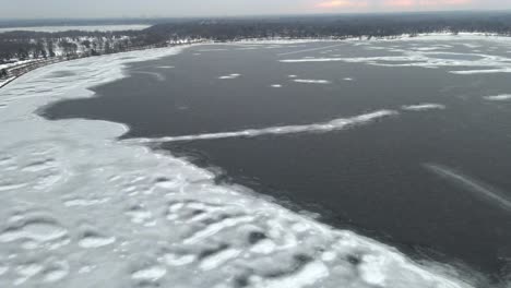 aerial view of a half frozen lake