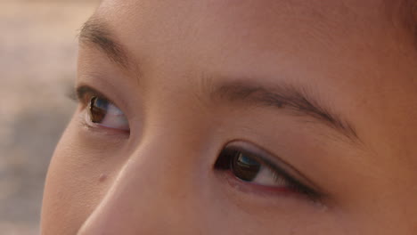 close up portrait of beautiful asian woman enjoying seaside at sunset exploring spirituality looking up praying contemplating journey relaxing on beach