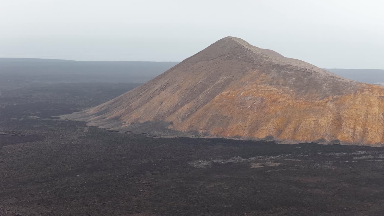 Scenic View Of Caldera Blanca On Dark Lava Plains On Misty Day In Lanzarote, Spain. wide drone shot