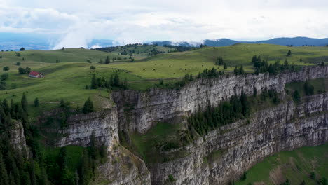 Rotating-drone-shot-of-Creux-du-Van-in-Switzerland,-located-at-the-border-of-the-cantons-of-Neuenburg-and-Vaud