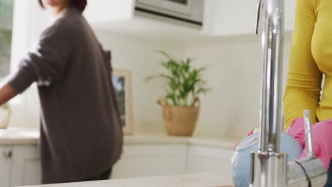 Biracial-Schwestern-Putzen-In-Zeitlupe-In-Der-Küche