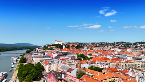 footage over the orange tops of the old-fashioned building in the historical part of the city. bratislava castle on the hill at backdrop