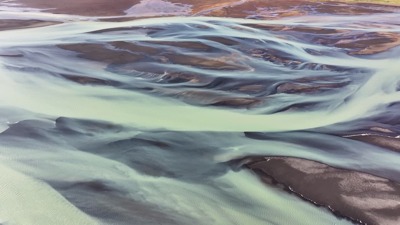 Aerial video showing the intricate runoff patterns formed from glacial meltwater flowing toward the ocean in Iceland
