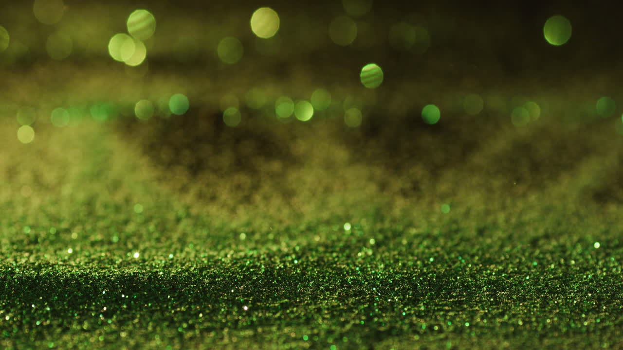 gemas de brillo verde derramándose sobre un fondo negro