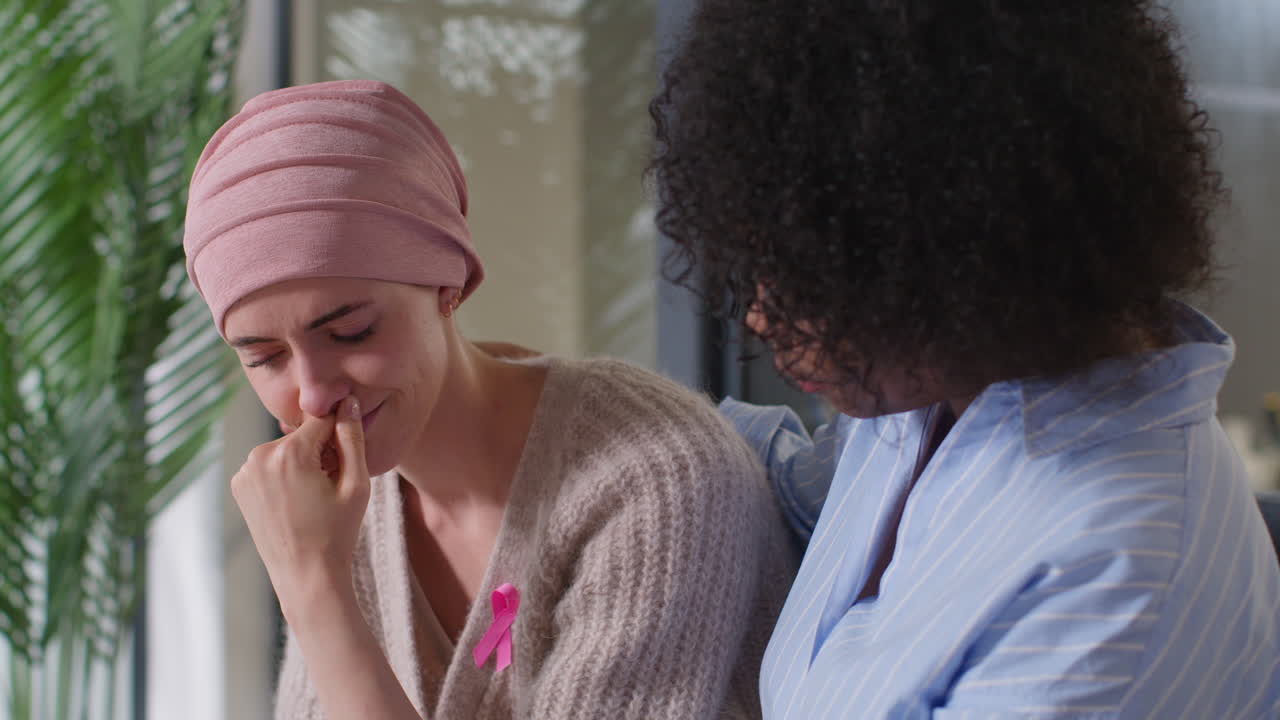 Upset Young Woman Patient Wearing Headscarf Receiving Chemotherapy Treatment For Breast Cancer Being Comforted By Female Patient 3