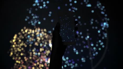 Silhouette-Einer-Hand,-Die-Ein-Feuerwerk-Mit-Einem-Smartphone-Aufzeichnet