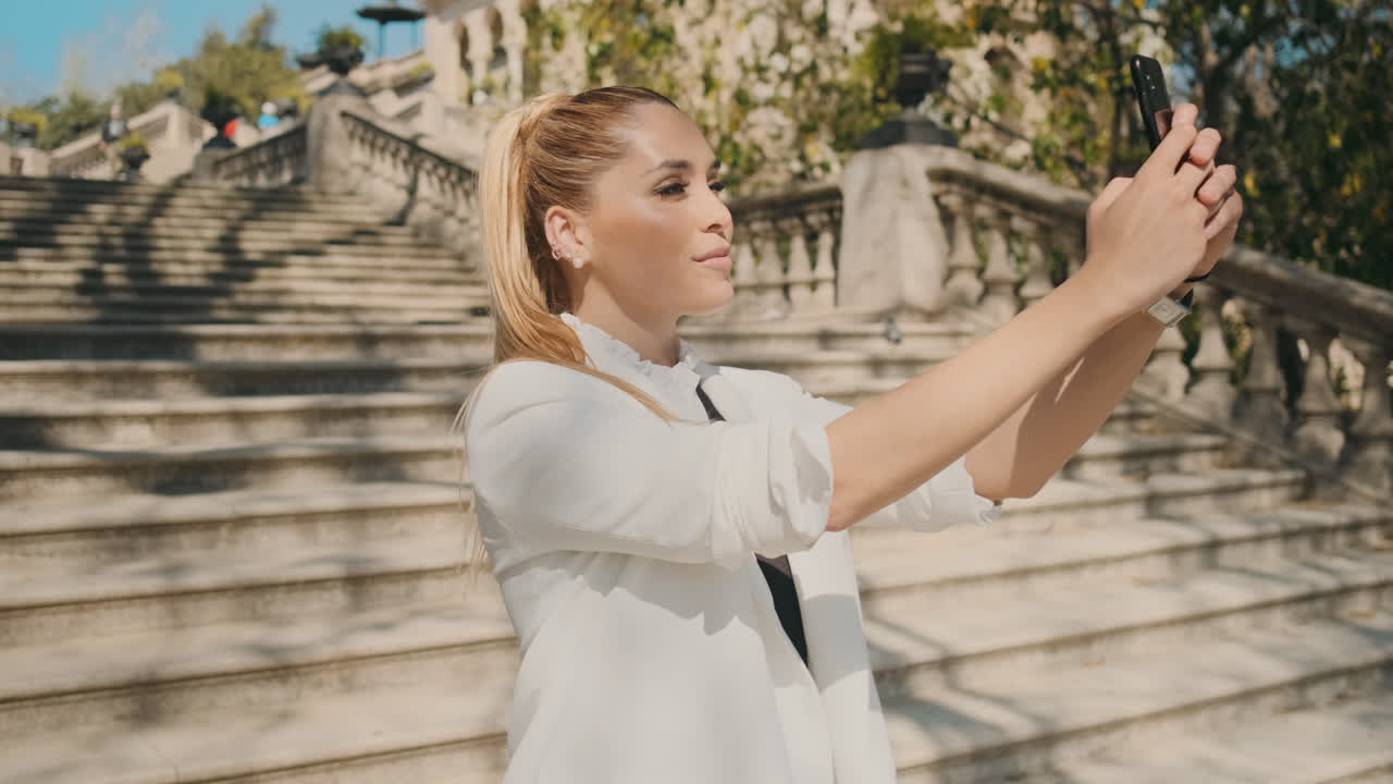 стильная молодая женщина делает селфи на открытом воздухе.