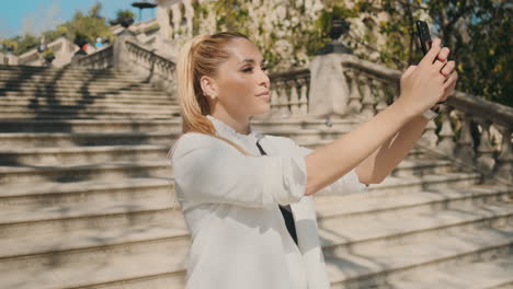 stylish young woman taking selfie outdoors.