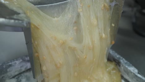 el primer plano de la masa de delicias turcas pegajosas calientes con almendras se vierte en una bandeja para enfriar
