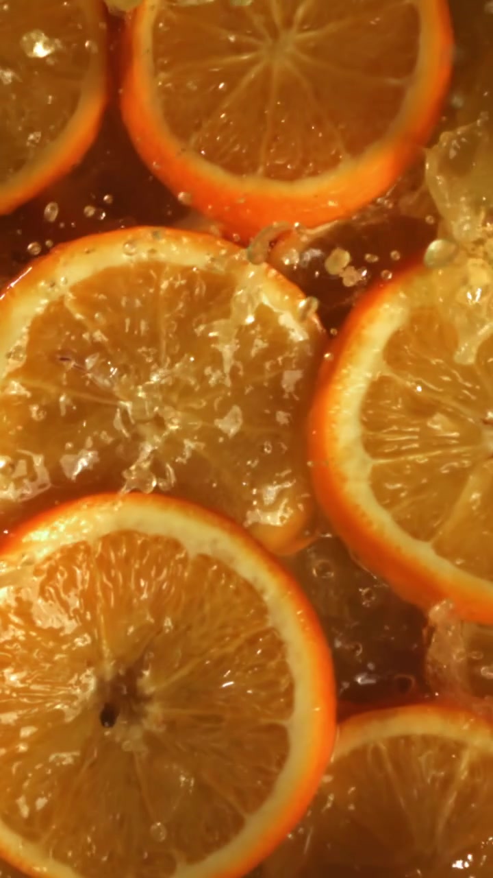 Fette d'arancia fresche che schizzano in acqua rinfrescante
