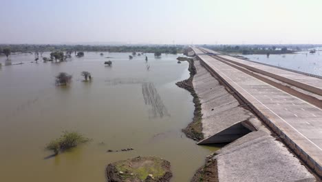 new causeway road along the murky lake with riprap wall