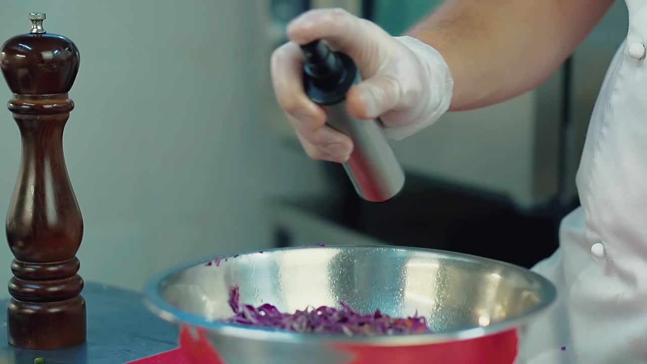 el cocinero rocía el spray sobre la cebolla azul preparada para la ensalada