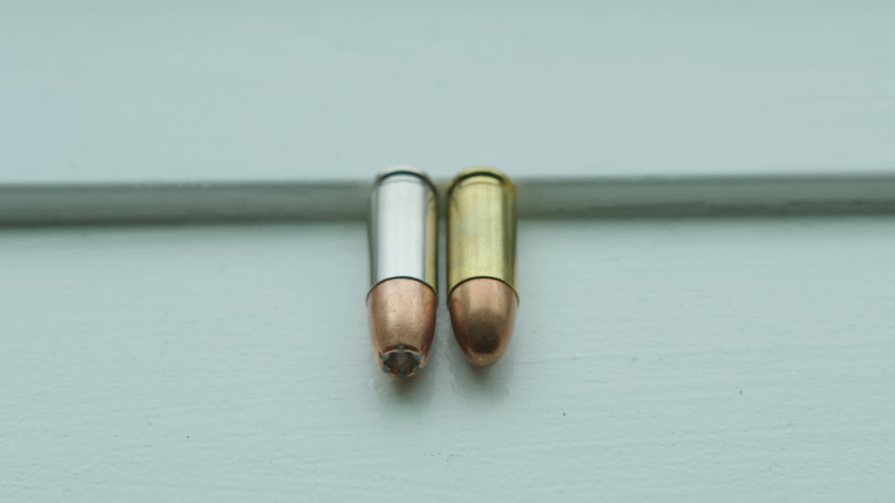 Close Up Pan Right of a Hollow Point and a Round Nose 9mm Bullet Side by Side