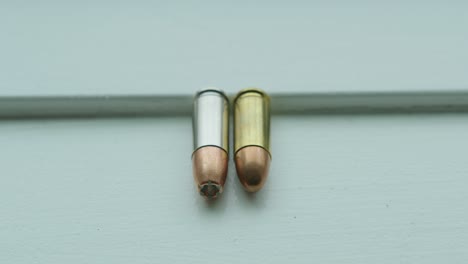 Close-Up-Pan-Right-of-a-Hollow-Point-and-a-Round-Nose-9mm-Bullet-Side-by-Side