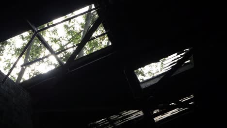 Broken-skylight-windows-in-old-abandoned-factory-panning-shot
