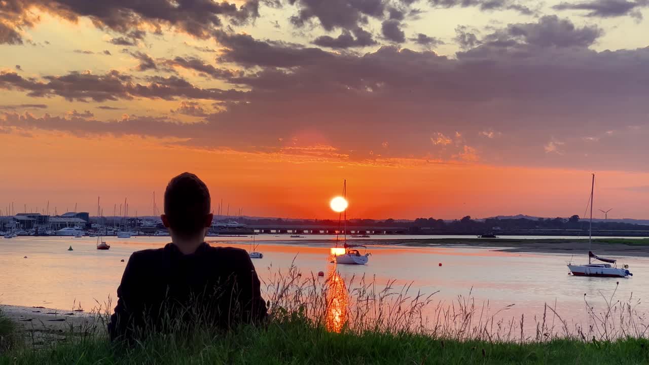 Person Relaxing at Malahide Marina Watching Peaceful Boats During a Glowing Irish Sunset