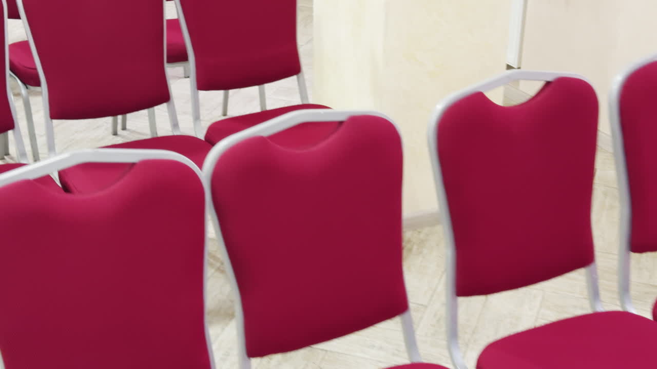 Ceremony room furniture close up. Pink chairs in the rows prepared for occasion.