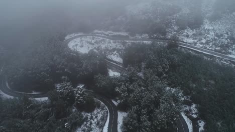 Neblige-Straße,-Die-Im-Winter-Mit-Schnee-Von-Einer-Drohne-Geschossen-Wird