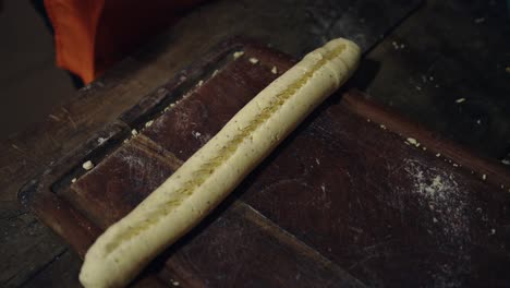 woman adding cheese to paraguayan chipa, ready to go into the tatakua, a traditional paraguayan clay oven