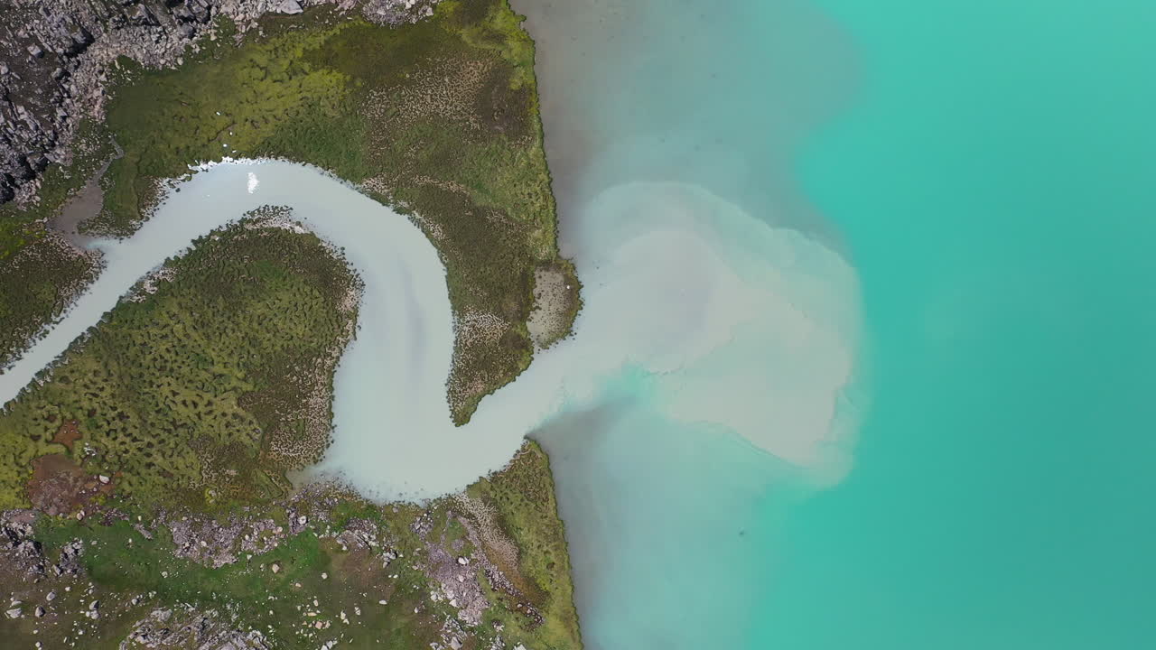 키르기스스탄의 알라콜 호수로 흐르는 강의 공중 드론 샷, 아래쪽 각도