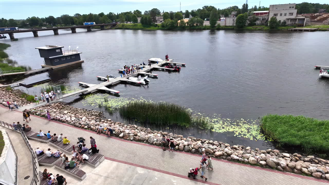 Peoples gathering in front of Boat docks moored at the edge of the harbor in Greece