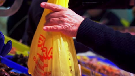 slow motion shot of a customer buying fresh fish from a street market in barbate, cadiz