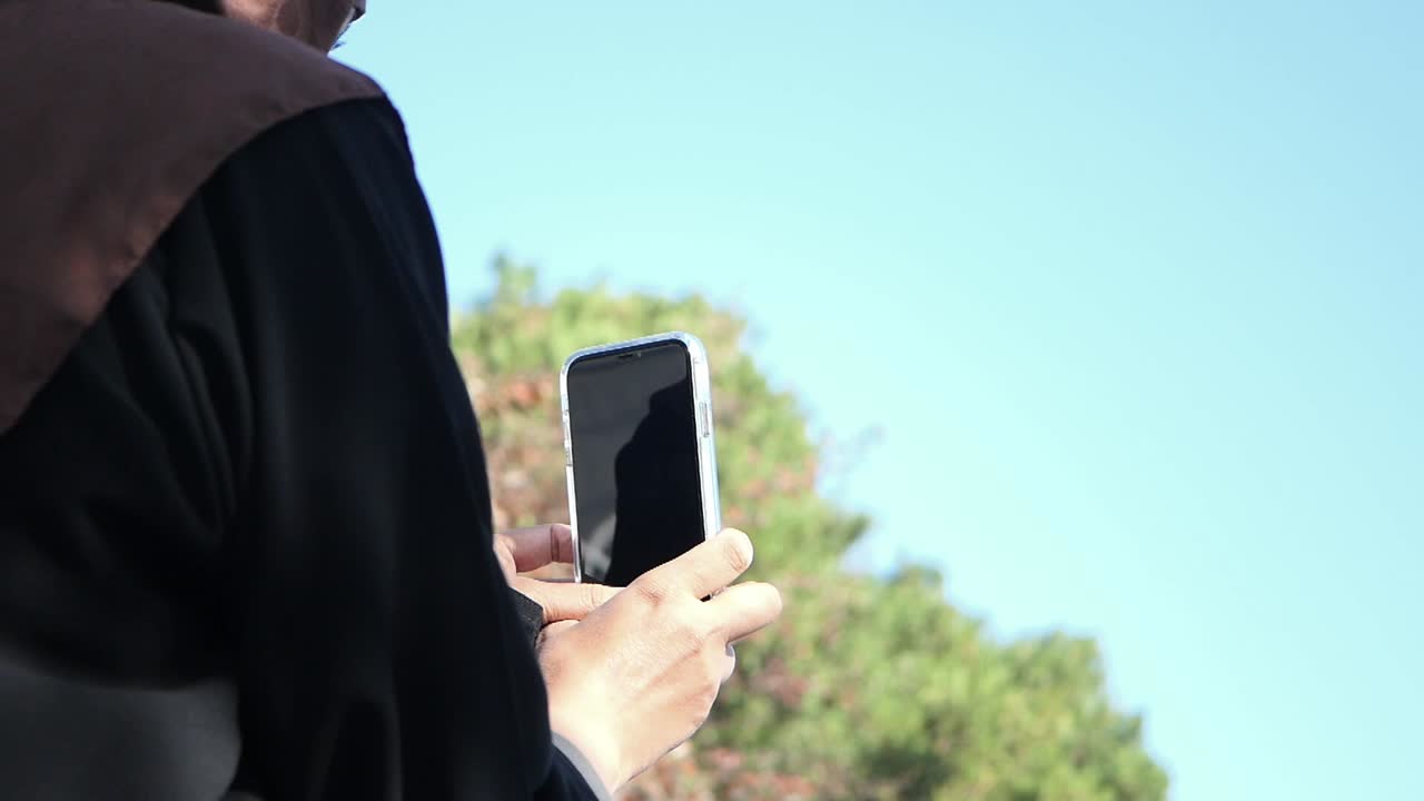 밖에서 스마트폰을 사용하는 여성