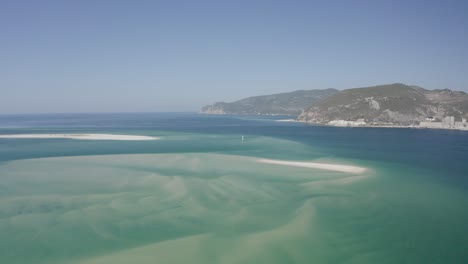 Vista-Aérea-De-Una-Playa-Paradisíaca-Tropical-Con-Arena-Blanca-Y-Agua-Clara-En-El-Parque-Natural-Arrabida-En-Setubal,-Portugal