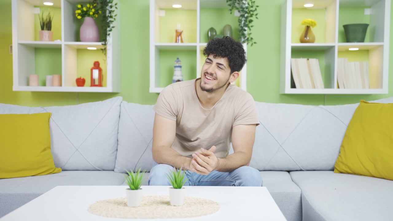 Young man at home thoughtfully, daydreaming.