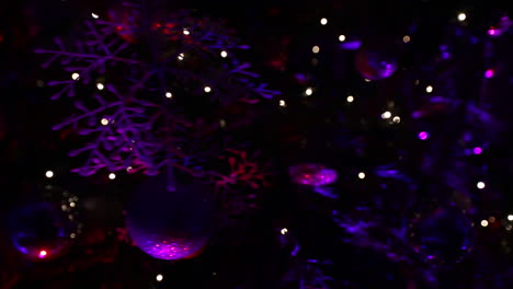 Christmas-tree-decorations-at-night-with-purple-lights---camera-rotate-around-the-tree