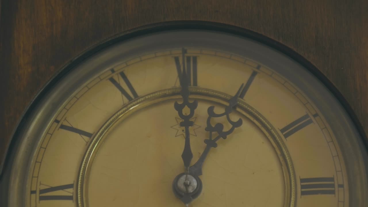 primer plano de un péndulo con manos y números romanos para marcar el tiempo, es 1:05 pm