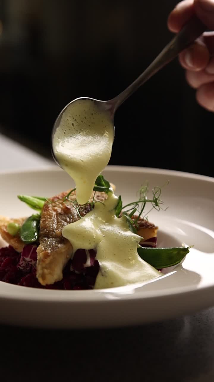 Chef Pouring Foamy Sauce Over Gourmet Fish Dish