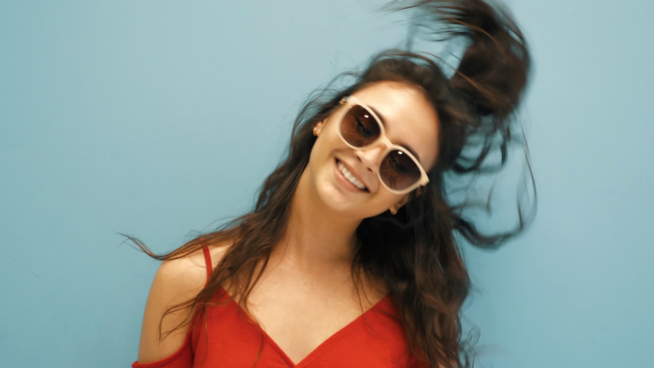mujer feliz en vestido rojo con gafas de sol