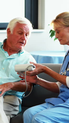 a nurse measuring blood pressure of a senior man