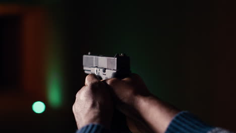 shooting gallery client using handgun to hit paper targets with ammo, close up